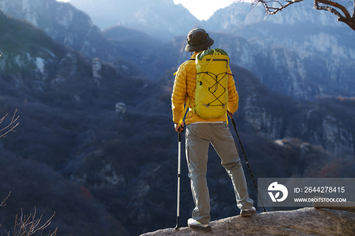 青年登山者站在山顶俯瞰