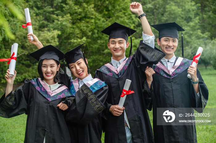 户外兴奋的穿着学士服大学生