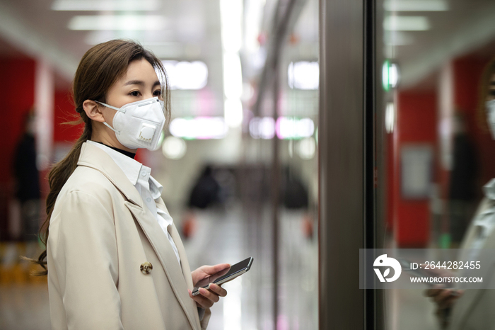 年轻女人站在地铁站台上