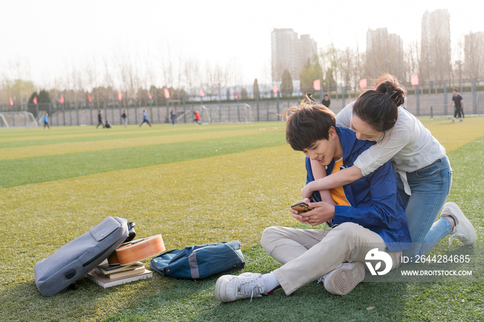 大学生情侣坐在校园里