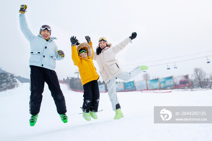 快乐的三口家庭在雪地上嬉戏