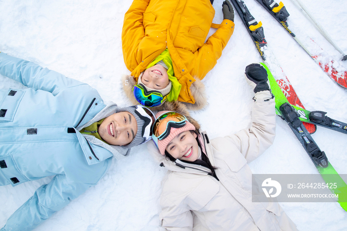 快乐的一家三口躺在雪地上