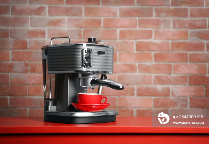 New electric coffee maker on brick wall background