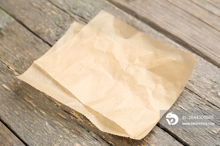 Sheets of baking paper on wooden background, closeup