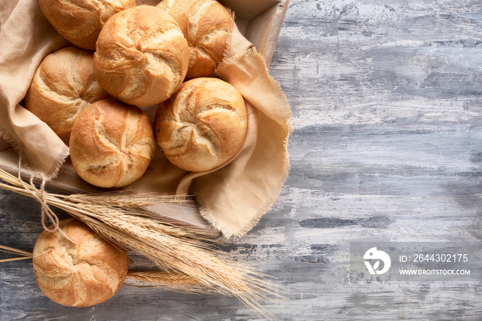 Crusty round bread rolls, known as Kaiser or Vienna rolls on linen towel