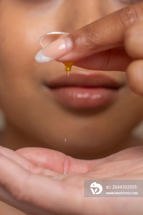 Close-up of woman dropping skin serum on hand