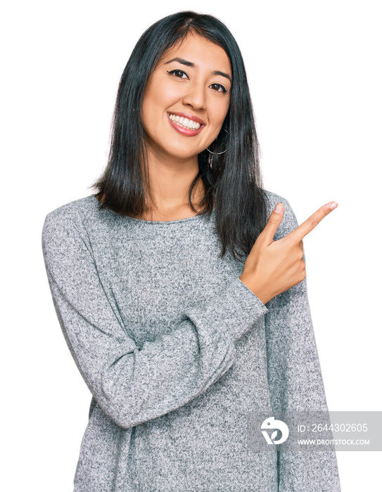 Beautiful asian young woman wearing casual clothes cheerful with a smile of face pointing with hand and finger up to the side with happy and natural expression on face