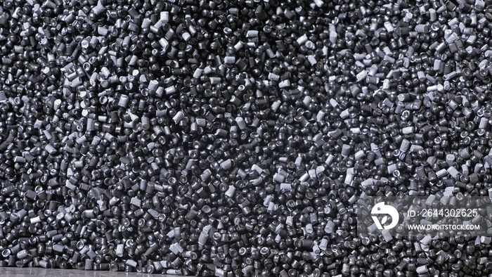 Plastic black gray granulated crumb. Manufacture of plastic water pipes of the factory. Process of making plastic tubes on the machine tool with the use of water and air pressure.