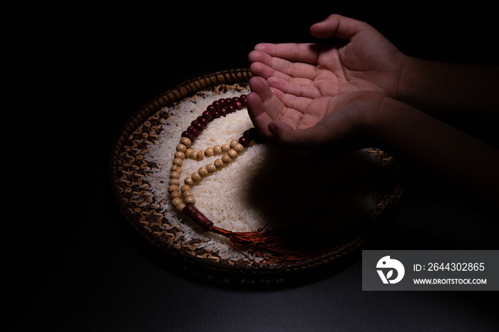 ZAKAT donation for Muslim according to religious principles during the Ramadan month,  concept: rice grain in bow and rosary on wood