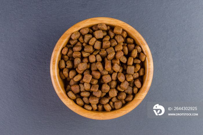 dog food in a bowl on black background, flat lay