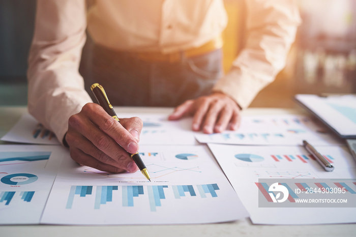 Close up hands of businessman analysis financial chart and graph on table desk.