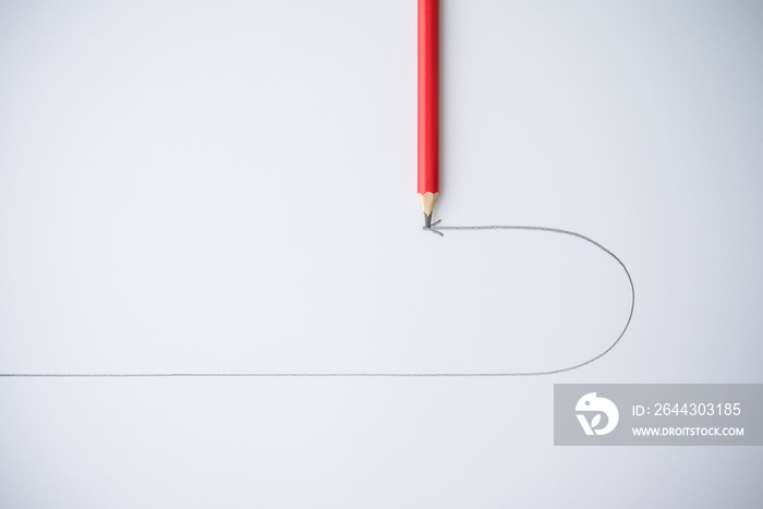 Flat lay of red pencil draw turning point arrow line on white background. Business, financial and education concept. Leader decide to change direction turning point to better way for success target.