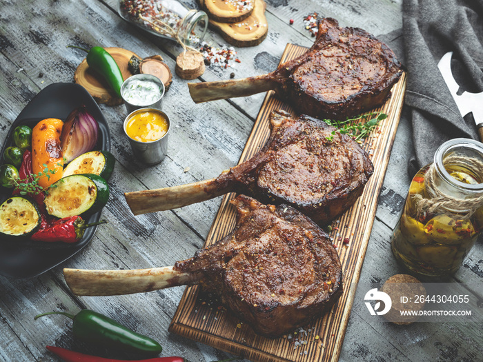 Grilled lamb, beef meat chops with vegetables on a serving board. Rustic food concept