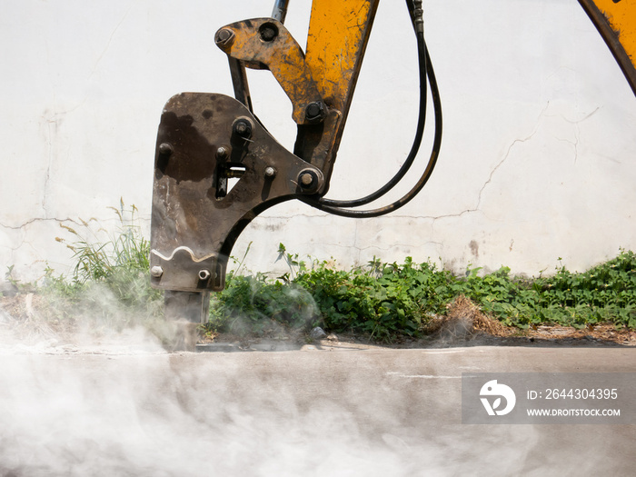 Machine is working to drill the concrete pavement Causing dust smoke and noise pollution The operation of machine to drill the road surface