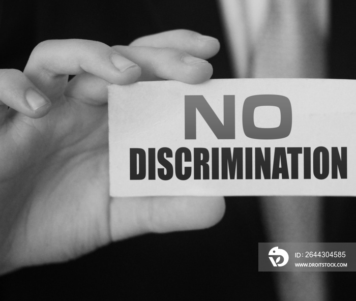 No discrimination words on a card in businessman hand. Social concept against racial and gender discrimination at work