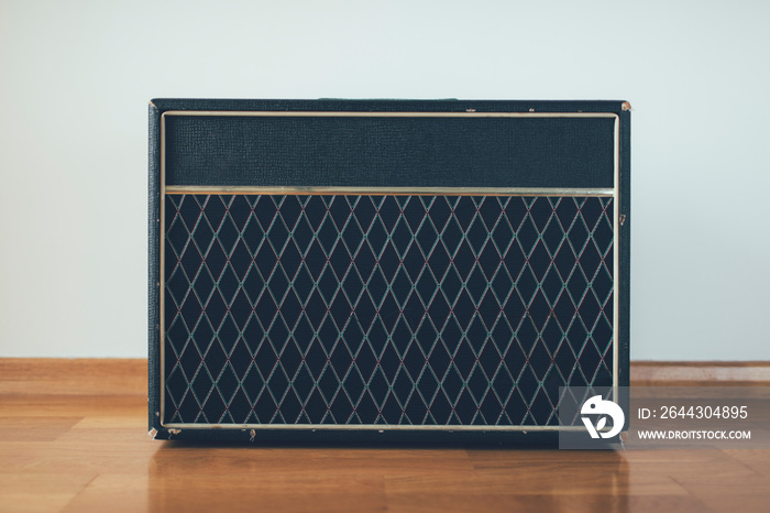 Classic guitar amplifier at white wall background