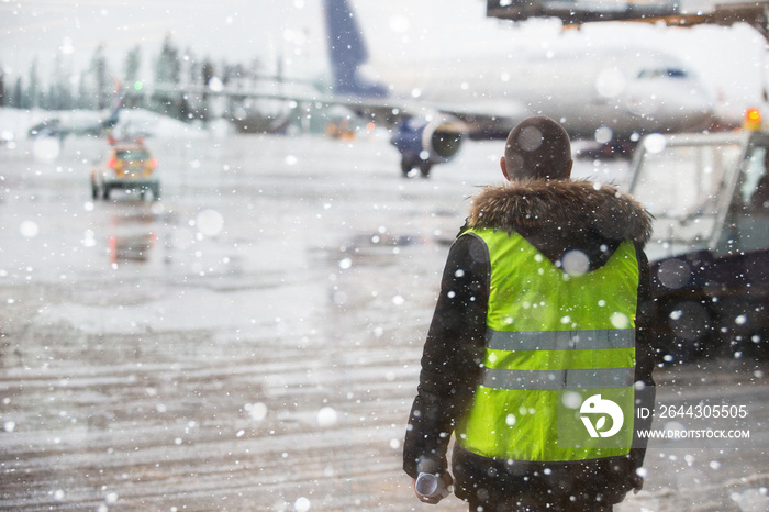 Airport manager standing under snowfall