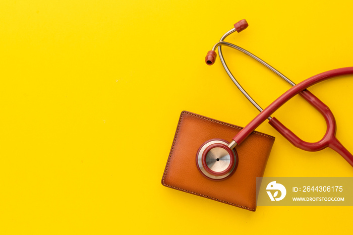 Doctor stethoscope and the new leather brown men wallet on yellow background. Budget for health check or money and financial concept