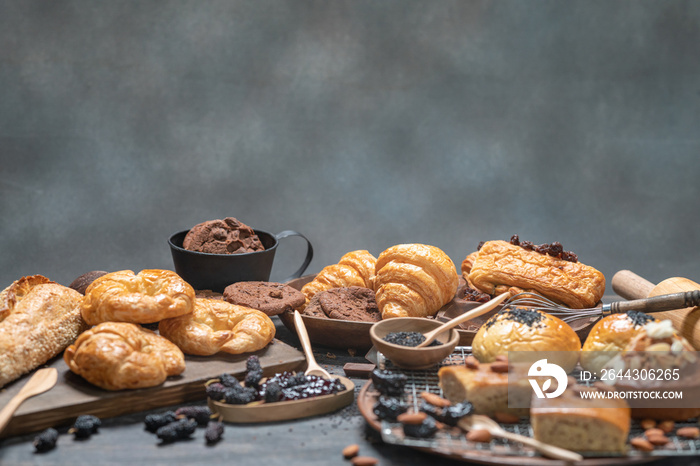 Assort of Bakery, Croissant, Chocolate chip cookie on wooden table with copy space.