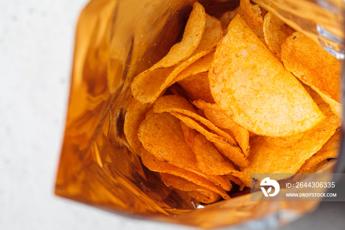 Potato chips with paprika spice in bag. Fast food concept.