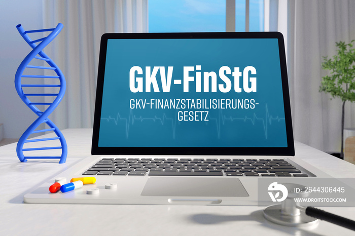 GKV-FinStG (GKV-Finanzstabilisierungsgesetz). Laptop mit Begriff/Text auf Monitor. Computer von Arzt im Büro. DNA und Stethoskop. Medizin, Gesundheitswesen