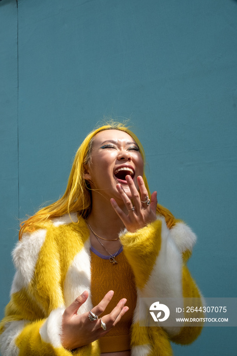 Young woman with yellow hair laughing outdoors