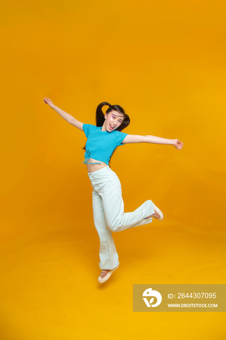 Studio portrait of smiling girl jumping