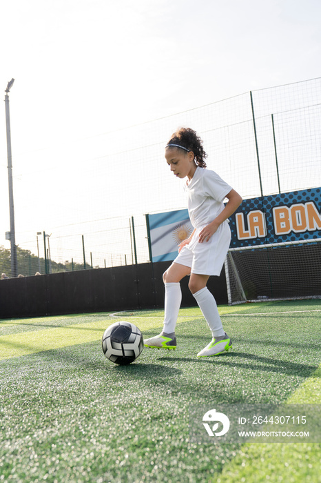 Girl (6-7) playing soccer on soccer field