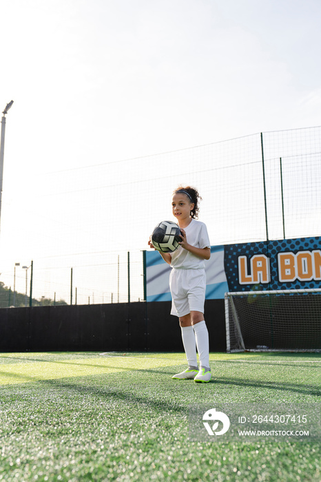 Girl (6-7) playing soccer on soccer field