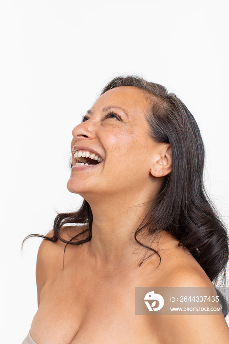 Studio portrait of shirtless woman laughing