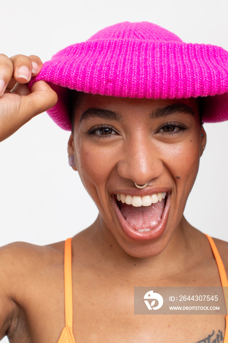 Studio portrait of smiling woman in pink woolen cap