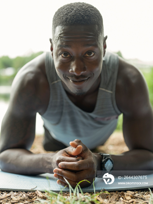 Portrait of man exercising doing plank on exercise mat