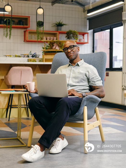 Man using laptop in office cafeteria