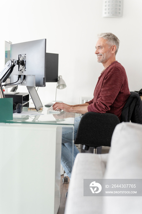 Mature man working on computer at home