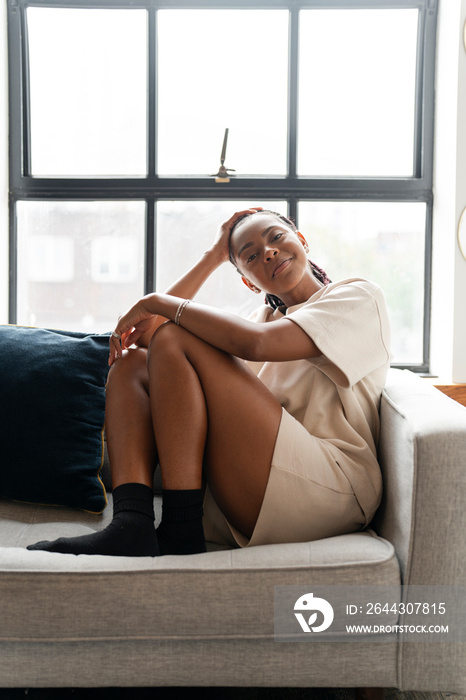 Portrait of young woman resting on sofa at home