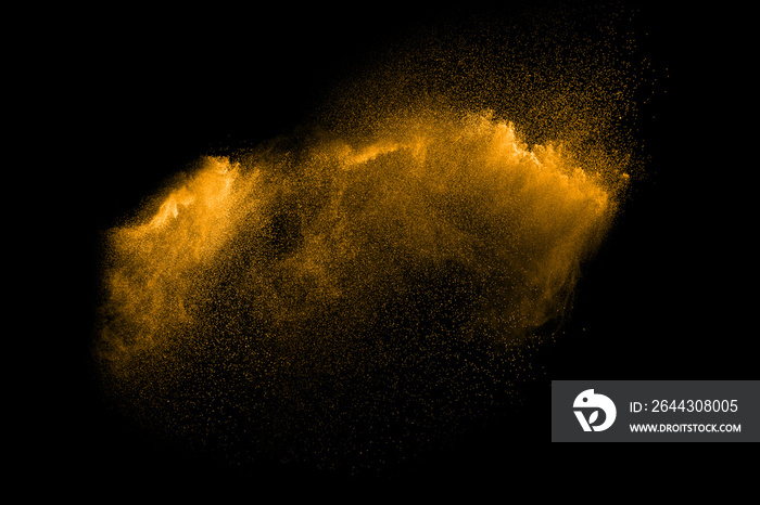 Golden sand explosion isolated on black background. Abstract sand cloud. Golden colored  sand splash against    dark background. Yellow sand fly wave in the air.