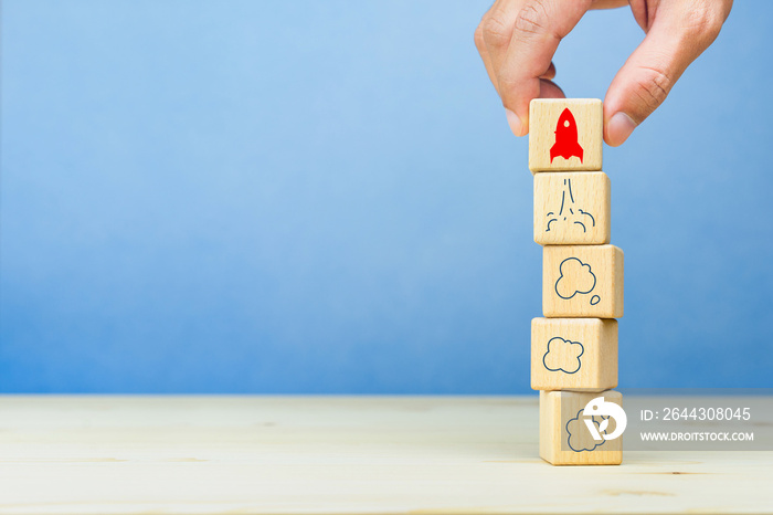 Business start up, Development and Innovation product. Businessman hand holding wooden block with rocket launch icon