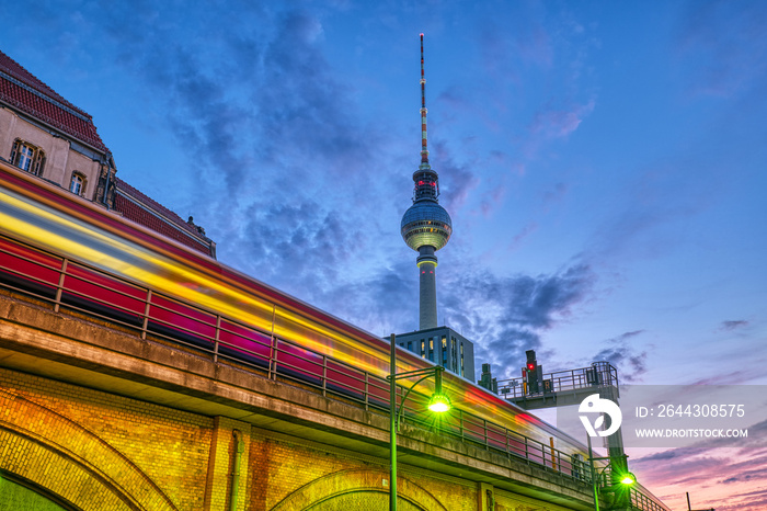 Local train with motion blur and the famous Television Tower in Berlin at night