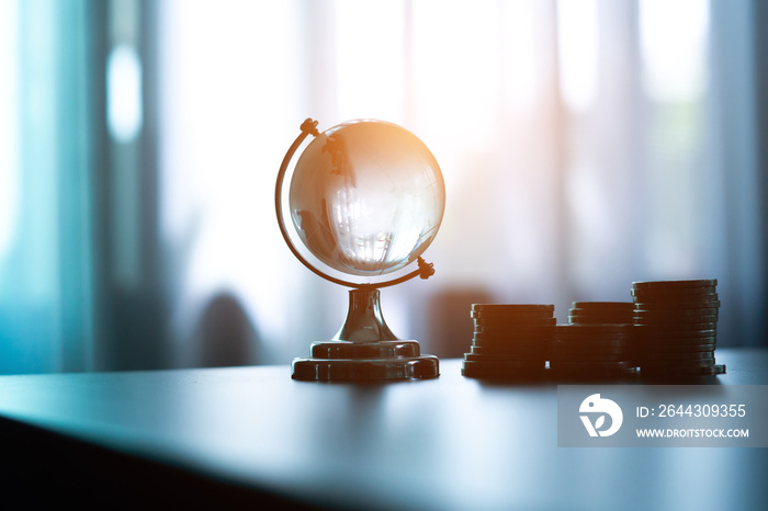 Glass globe and coin on the table in Business finance concept