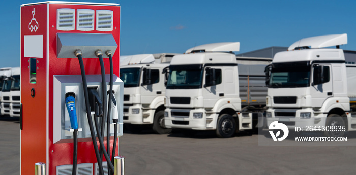 Electric vehicles charging station on a background of a row of trucks. Concept