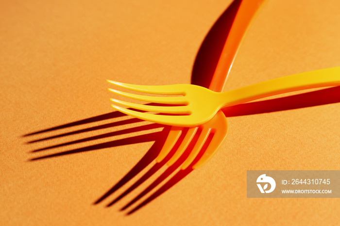 Plastic forks on color background