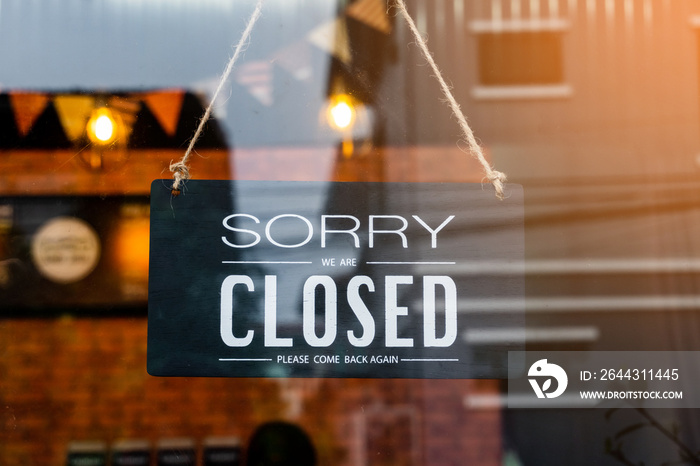 Sorry we’re closed . vintage black and white retro sign on a coffee glass door