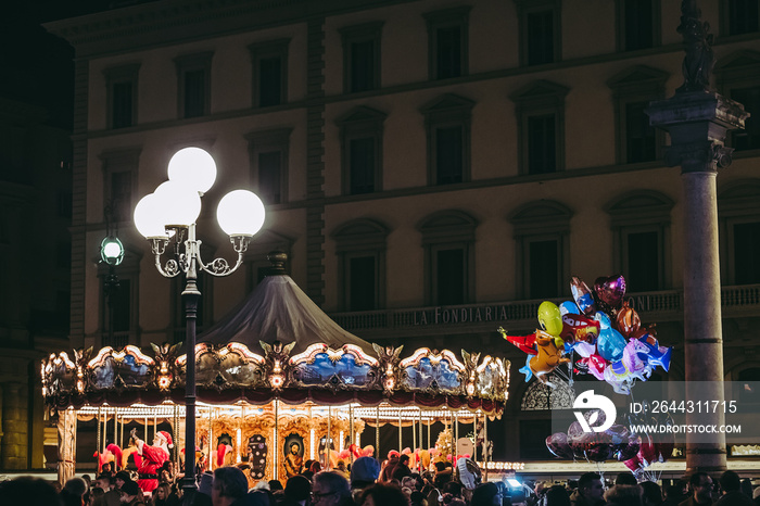 Grand carrousel sur une place, lumières dans la nuit