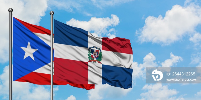 Puerto Rico and Dominican Republic flag waving in the wind against white cloudy blue sky together. Diplomacy concept, international relations.