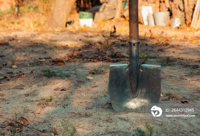 Close up of shovel head dug into sand and rock dirt at ceremonial ground breaking event for commercial and residential building development