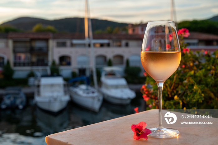 Tasting of local rose wine in summer with sail boats haven of Port Grimaud on background, Provence, France