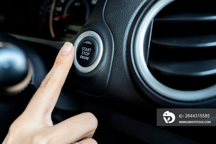 Using the push button to start and stop engine, The woman’s finger is pressing down.