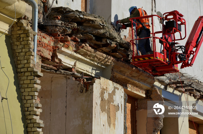 demolition of an apartment building worker on a forklift using a jackhammer. creates an apocalyptic scene. clearing work after the bombing. reconstruction of the historic castle building