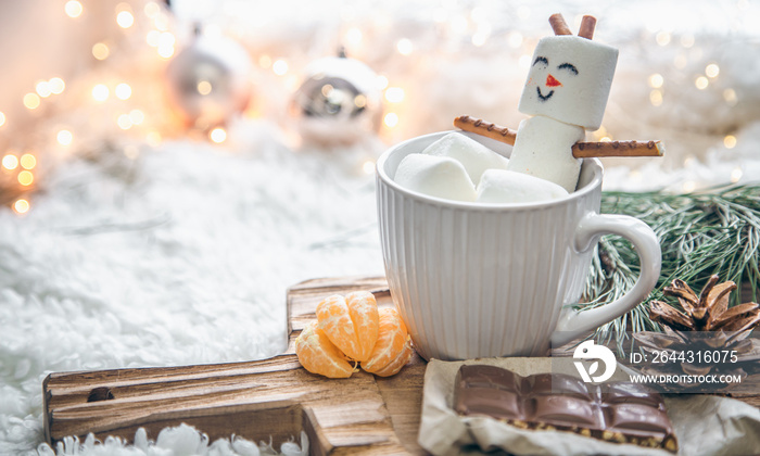 Christmas background with marshmallow snowman in a cup.