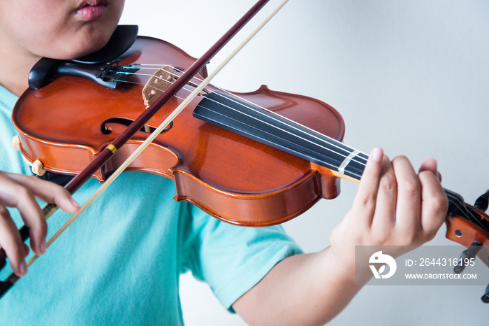 Boy playing violin in room